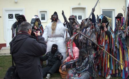 Ein Gruppe Maskierter und Trachtenträger wird fotografiert