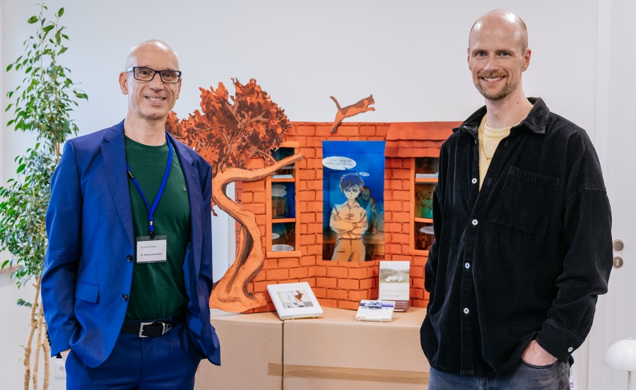 Mate Eichenseher vom HdH BW und Florian Bayer von der Merz Akademie vor einem gestalteten Koffer-Objekt der Studierenden